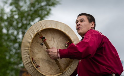 The shaman beats the tambourine