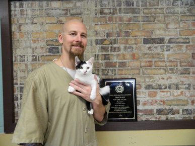 The cat is in the hands of a prisoner